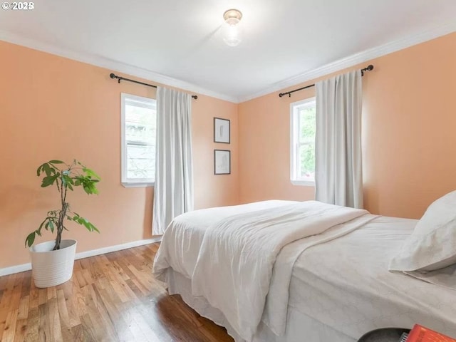 bedroom with crown molding and light wood-type flooring