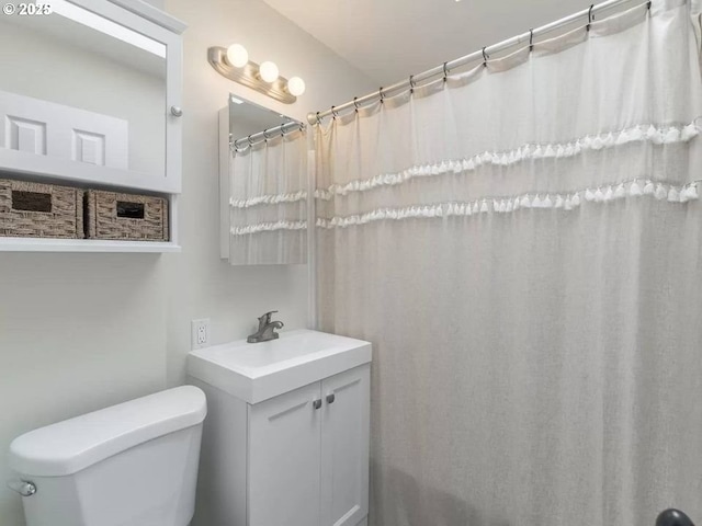 bathroom featuring vanity, a shower with shower curtain, and toilet