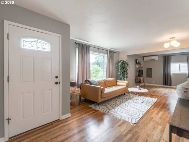 foyer featuring wood-type flooring, plenty of natural light, and a wall mounted AC