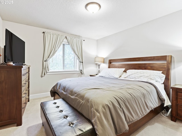 bedroom with light carpet and a textured ceiling