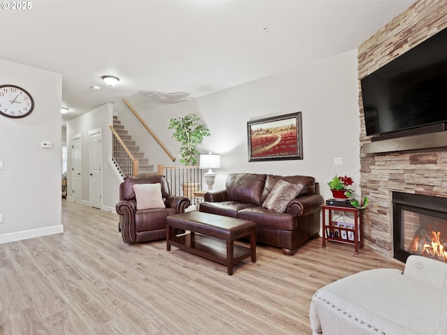 living room featuring light wood-type flooring and a fireplace