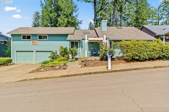 view of front of home with a garage, a chimney, concrete driveway, and a shingled roof