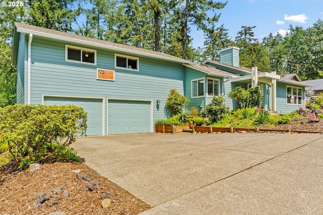 view of front of property featuring driveway, a chimney, and a garage