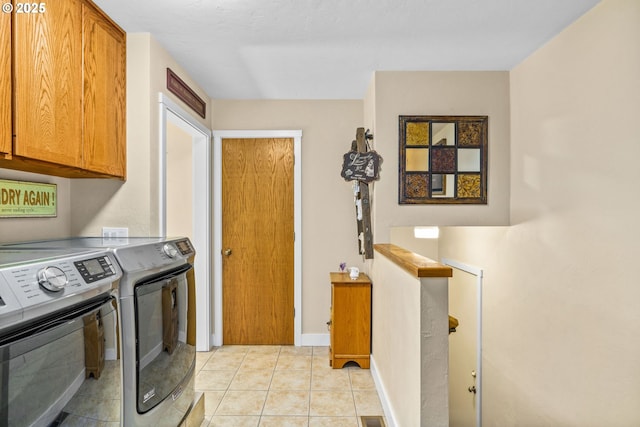 laundry room with baseboards, cabinet space, light tile patterned floors, and washer and dryer