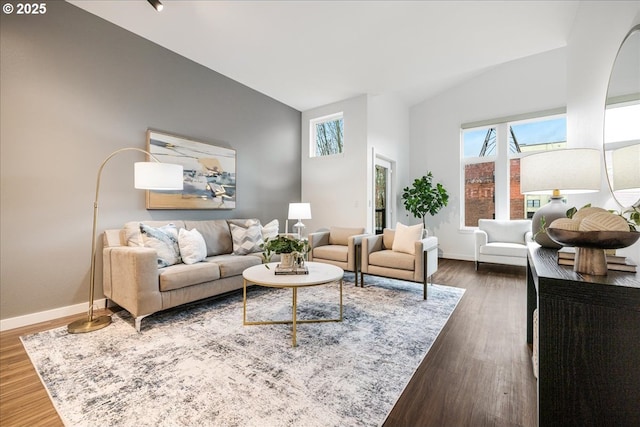 living room with a high ceiling, wood finished floors, and baseboards