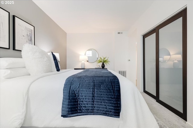 carpeted bedroom featuring visible vents