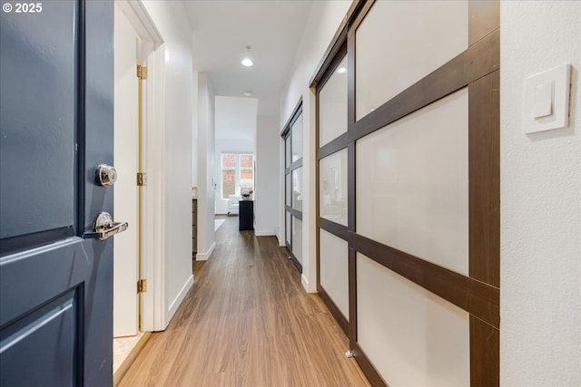 hallway featuring baseboards and wood finished floors