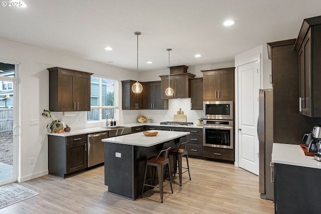 301 W 17th St, Lafayette, OR 97127 - kitchen with appliances with stainless steel finishes, dark brown cabinetry, decorative backsplash, a center island, and recessed lighting