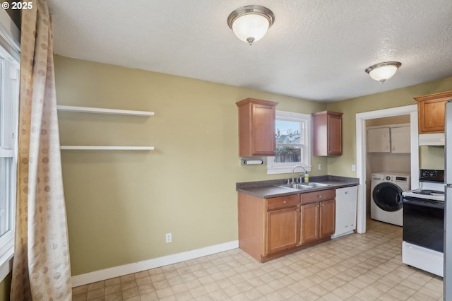 kitchen with sink, dishwasher, electric range oven, a textured ceiling, and washer / clothes dryer