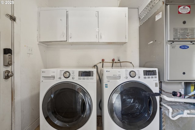 washroom with cabinets and washer and dryer