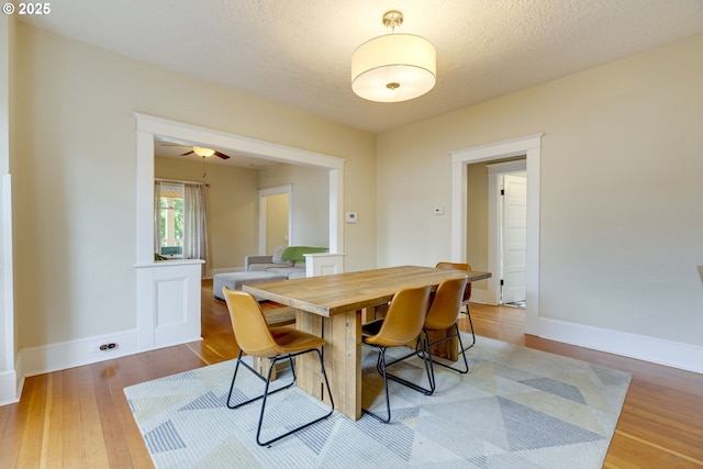 8113 SE Morrison St, Portland, OR 97215 - dining area featuring wood finished floors, baseboards, a ceiling fan, and a textured ceiling