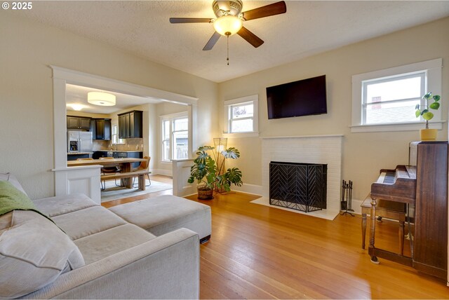 8113 SE Morrison St, Portland, OR 97215 - living area with a ceiling fan, light wood-style floors, and a fireplace