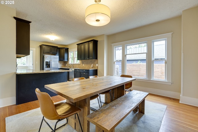 8113 SE Morrison St, Portland, OR 97215 - dining area with baseboards, a textured ceiling, and light wood finished floors