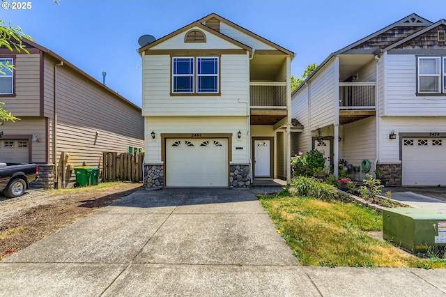 2482 25th Ave, Forest Grove, OR 97116 - view of front of home with stone siding, a garage, a balcony, and driveway