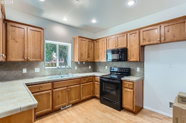 2482 25th Ave, Forest Grove, OR 97116 - kitchen featuring black appliances, light wood-style floors, brown cabinets, tasteful backsplash, and recessed lighting