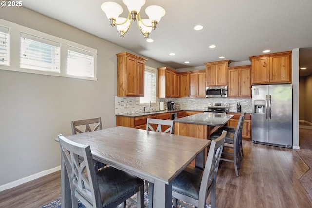 dining area featuring baseboards, dark wood-type flooring, recessed lighting, and a chandelier