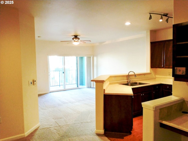 kitchen featuring light carpet, sink, kitchen peninsula, ceiling fan, and dark brown cabinets