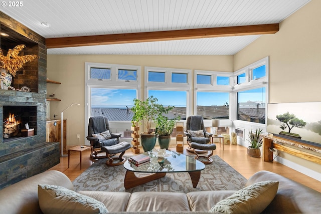 living room with a large fireplace, beam ceiling, and light hardwood / wood-style floors