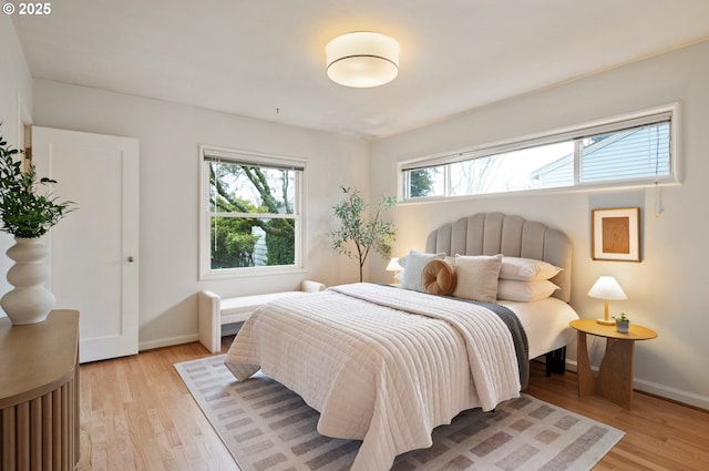 bedroom featuring baseboards and light wood-style floors