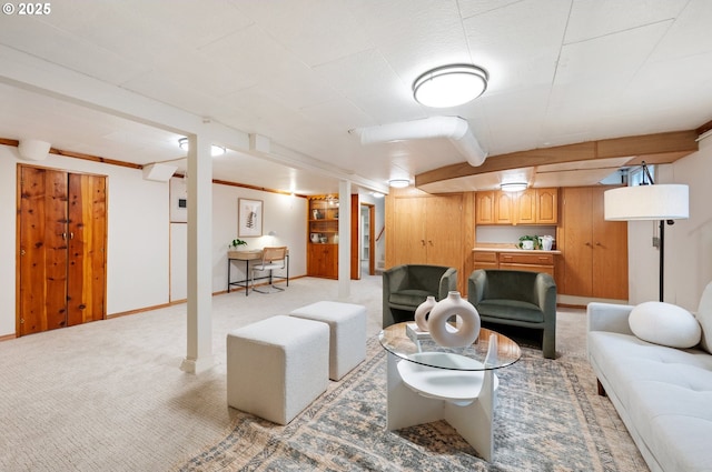 living area with baseboards and light colored carpet