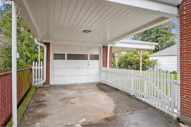 view of patio with driveway, an attached garage, and fence