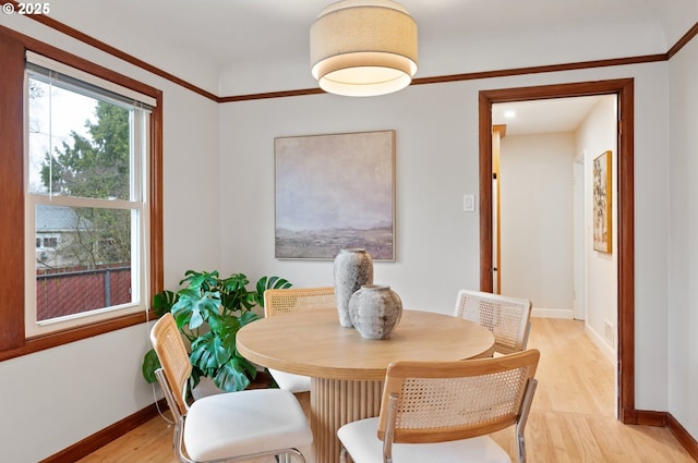 dining area featuring light wood-style flooring and baseboards