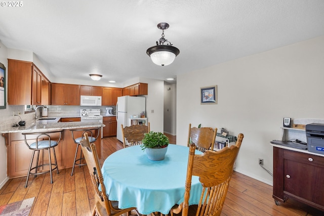 dining area featuring sink and light hardwood / wood-style flooring