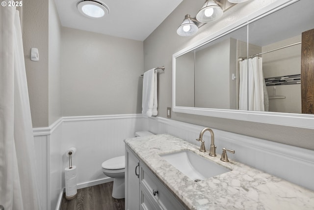 bathroom featuring vanity, hardwood / wood-style floors, curtained shower, and toilet