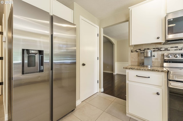 2614 NE 176th Ave, Vancouver, WA 98684 - kitchen featuring stainless steel appliances, white cabinets, light tile patterned floors, and backsplash