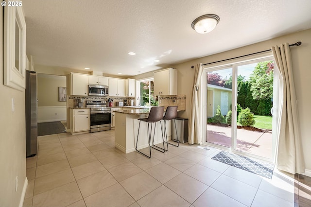 2614 NE 176th Ave, Vancouver, WA 98684 - kitchen featuring stainless steel appliances, a peninsula, baseboards, white cabinets, and a kitchen breakfast bar