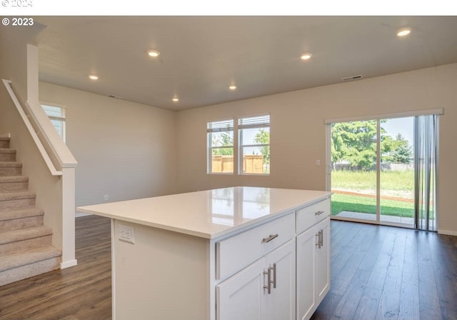 kitchen with white cabinetry, plenty of natural light, a center island, and dark hardwood / wood-style floors