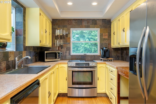 10001 SW 35th Ave, Portland, OR 97219 - kitchen with appliances with stainless steel finishes, light countertops, tasteful backsplash, recessed lighting, and light wood-type flooring