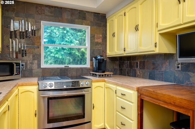 10001 SW 35th Ave, Portland, OR 97219 - kitchen featuring stainless steel appliances, tasteful backsplash, light countertops, and cream cabinetry