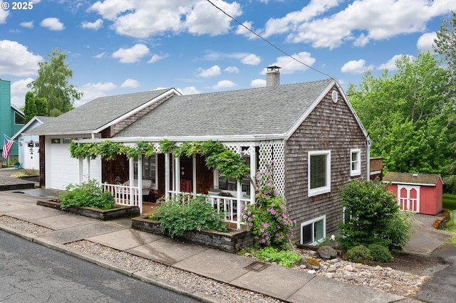 10001 SW 35th Ave, Portland, OR 97219 - view of front of house with covered porch, a shingled roof, a chimney, a storage unit, and an attached garage