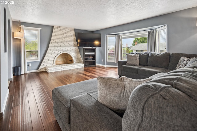 3780 SE 21st Dr, Gresham, OR 97080 - living room with wood-type flooring, baseboards, a brick fireplace, a textured ceiling, and healthy amount of natural light