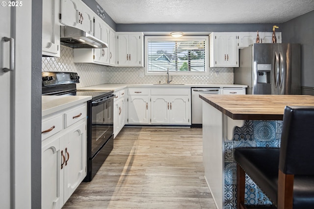 3780 SE 21st Dr, Gresham, OR 97080 - kitchen with appliances with stainless steel finishes, under cabinet range hood, a sink, a textured ceiling, and light wood-style floors