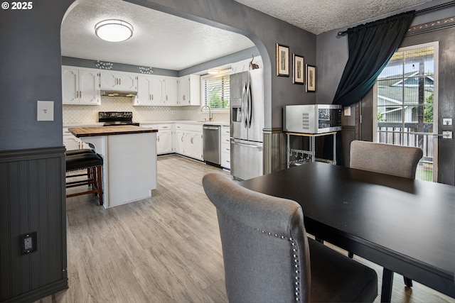 3780 SE 21st Dr, Gresham, OR 97080 - dining area with arched walkways, a textured ceiling, and light wood-type flooring