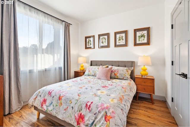 bedroom featuring a closet, baseboards, and wood finished floors