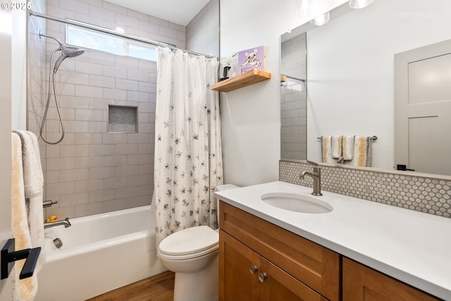 bathroom with toilet, wood finished floors, shower / tub combo with curtain, and vanity