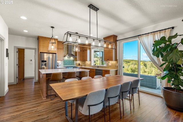 dining area with dark wood-style floors, a textured ceiling, baseboards, and recessed lighting