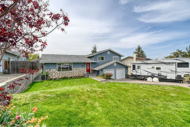 split level home with fence, concrete driveway, roof with shingles, and a front yard