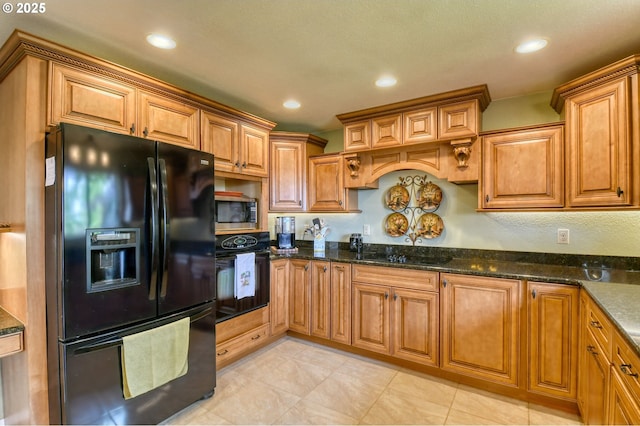 kitchen with recessed lighting, brown cabinets, dark stone countertops, light tile patterned floors, and black appliances