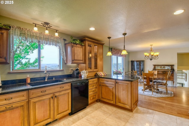 kitchen with a sink, brown cabinets, a textured ceiling, and dishwasher