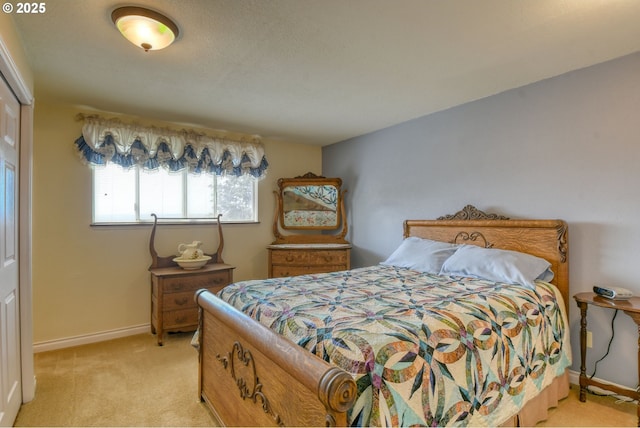 bedroom with light colored carpet and baseboards