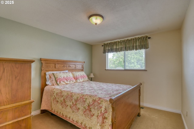 bedroom with baseboards, a textured ceiling, and light carpet