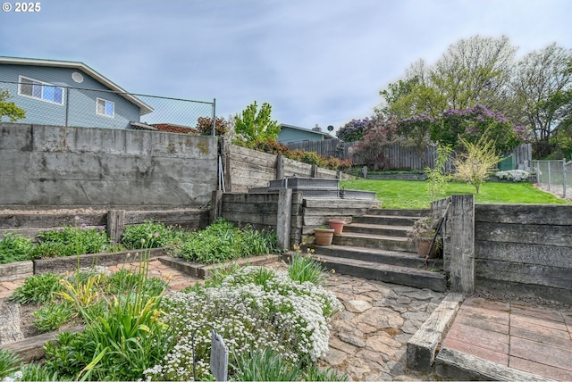 view of yard featuring fence and a vegetable garden
