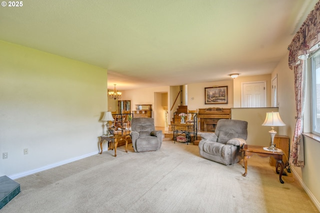 living area featuring plenty of natural light, carpet, a chandelier, and stairway