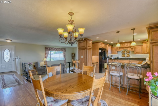 dining room with an inviting chandelier, recessed lighting, and light wood finished floors
