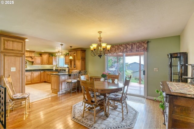 dining room with baseboards, recessed lighting, a textured ceiling, a chandelier, and light wood finished floors