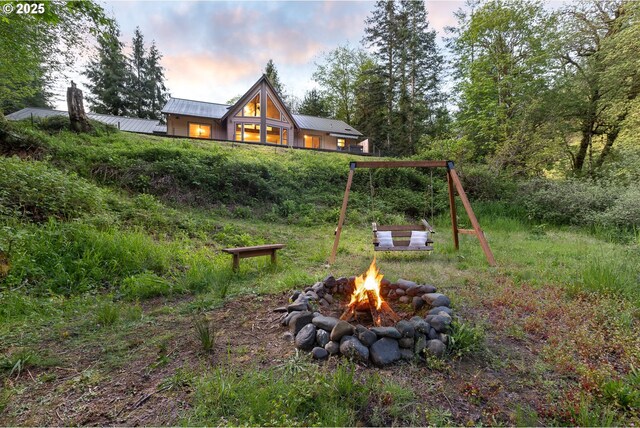 yard at dusk featuring an outdoor fire pit